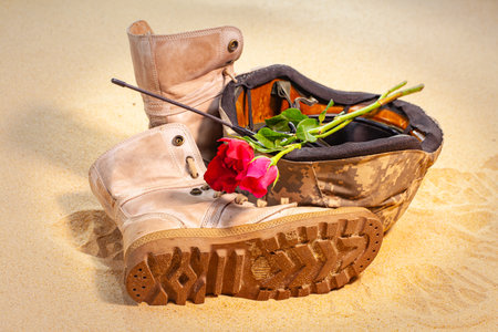 A solitary red rose is laid upon broken protective gear, standing as a quiet, heart wrenching tribute to bravery, remembrance, and the countless lives lost in the heat of battle.の写真素材