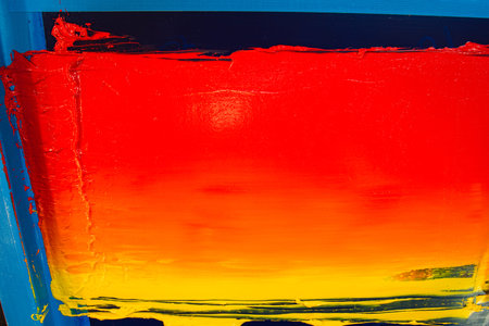 An artisan applies layers of warm colored inks on a screen, blending fiery hues to produce a smooth...