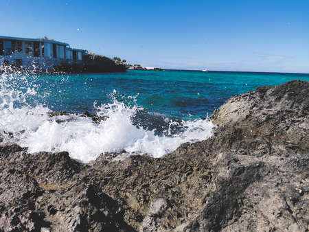 A wave breaks on a rockの写真素材