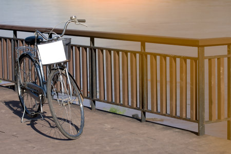 Bicycle with blank billboard on the bridge at sunset or sunrise.の写真素材