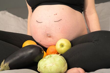 Healthy nutrition during pregnancy conjures up a smile on the face of the  baby bellyの写真素材