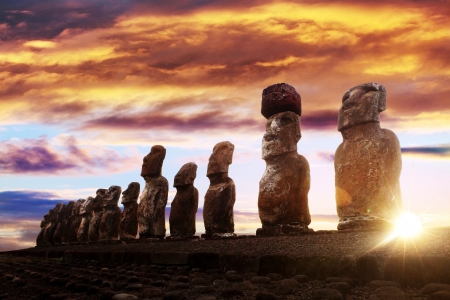 Standing moai in Easter Island against rising sun and orange skyの写真素材