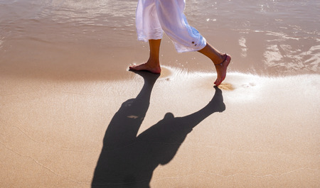 Feet of a woman walking on a sandy beachの写真素材