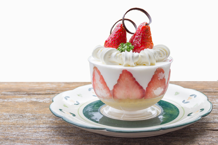 A small dessert with some strawberry with mint leaves on a white background.の写真素材