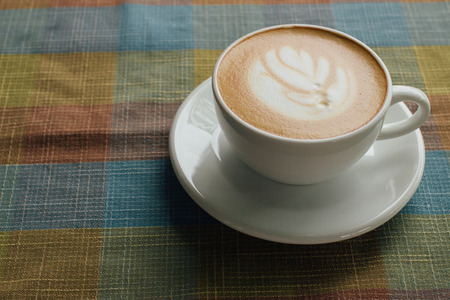 Coffee cup latte art with tree shape foam top view on wooden table background in coffee shopの写真素材