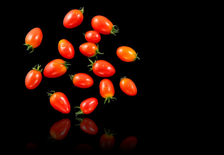 tomatoes floating with black background.の写真素材