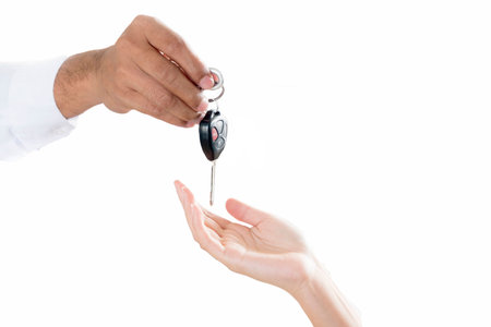 Close-up shoot of the car salesman hand giving a key to the owner.の写真素材