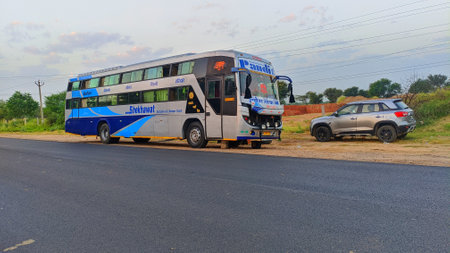 January 2020- Mahroli, Jaipur, India.
Bus travelling on the asphalt road in rural landscape at sunset.のeditorial素材