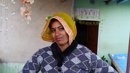 January 2020- Mahroli, Jaipur, India. Close up view of a traditionally dressed smiling woman of Indian origin, in front of his home.のeditorial素材