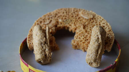 Indian disc-shaped Mithai, Ghevar sweet garnished closeup view with dry fruits. Delicious sweet with...