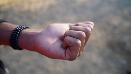 Hand gesture with close fingers with blurred background. Expression sign of Taking in Hindu culture and religion.の写真素材