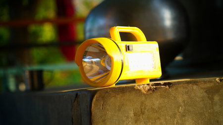 Yellow Electricity Torch closeup isolated on grey column. Yellow battery view, source of illumination to remove darkness.の写真素材