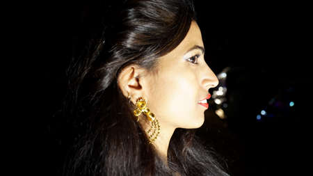 19 February 2021- Sikar, Jaipur, India. Side view cheek shot of Modal girl with black background. Beauty woman face portrait closeup.のeditorial素材