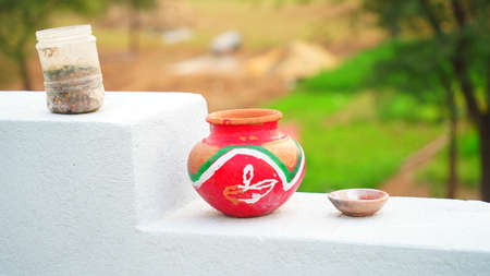 Isolated shot of red printed Clay pot holding on a temple stairs. Sacred clay pot for religious festivals and ceremony.の写真素材