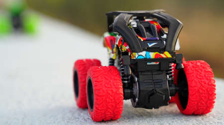 Truck toy closeup. Heavy plastic children plastic toy closeup with black and red wheels. Children playing equipments concept.の写真素材