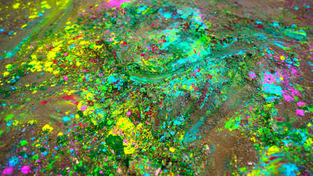 Closeup shot of splashing Gulaal color powder with green colors. Vibrant rainbow colors spreading on ground.の写真素材