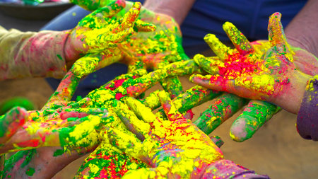 Cropped view of young hands with Yellow, Green and Red holi powder. Isolated shot of Gulal or Abhir colors closeup.の写真素材