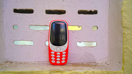 26 March 2021- Khatoo, Jaipur, India. Old keypad phone concept. Keypad mobile phone in a window with white keypad and black screen.のeditorial素材