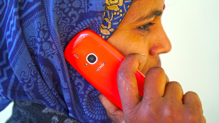 26 March 2021- Khatoo, Jaipur, India. Traditional Indian woman chatting on phone. Lady with red Nokia company mobile phone. Modern communication system concept.のeditorial素材