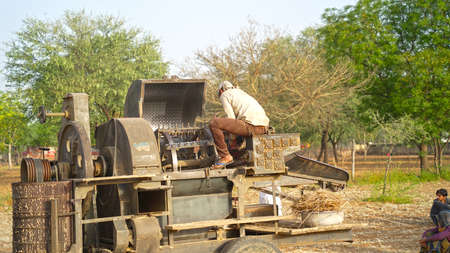 08 April 2021- Akhepura, Sikar, India. Man sharping thrasher blade in a agriculture field. Worker...