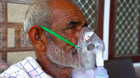 02 May 2021- Reengus, Sikar, India. Portrait of an elderly person, with oxygen mask. A elder person...