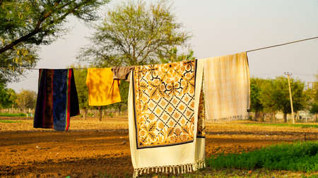 Colourful clean sheets outdoors. Drying on a rope on background of beautiful scenery in the garden.の写真素材