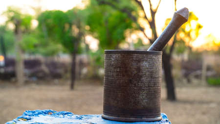 Evening shot, Iron mortar and pestle isolated on nature background. Still life concept.の写真素材