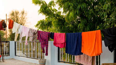 On roof, Rope with clean clothes outdoors on laundry day. Colorful clothes hanging in clothesline.の写真素材