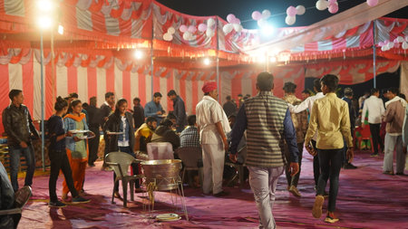 21 November 2021 Reengus, Rajasthan, India. Indian family members and gusts eating food at a marriage function.のeditorial素材