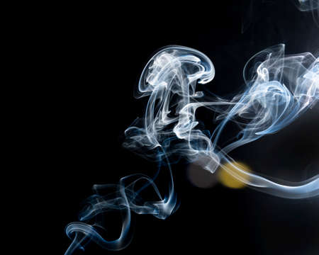 Flavored incense smoke burning. dramatic black background.の写真素材
