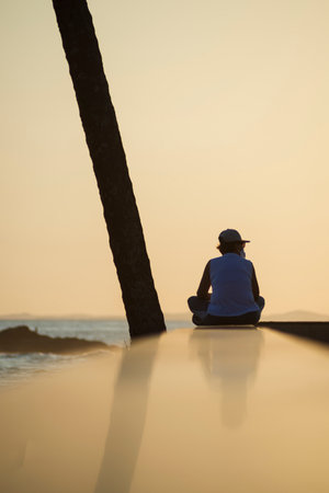 Salvador, Bahia, Brazil - October 06, 2020: Silhouette of a woman walking along the edge of Ondina beach at a beautiful orange sunset.のeditorial素材