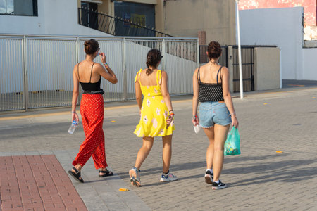 Salvador, Bahia, Brazil - March 20, 2021: Three women walk the streets of Farol da Barra on a very...