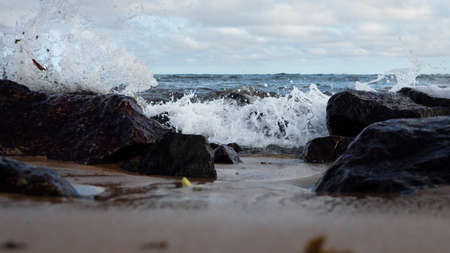 Blue sky and sea over the rocks and sand on the beach. Waves crashing on the rocks and sand on the beach.の写真素材