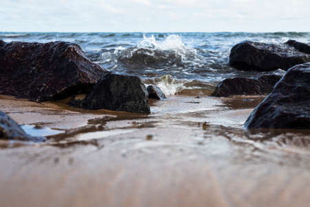 Blue sky and sea over the rocks and sand on the beach. Waves crashing on the rocks and sand on the beach.の写真素材
