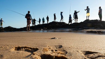 Salvador, Bahia, Brazil - April 25, 2021: Fishermen with their fishing rods on the rocks in search of fish.のeditorial素材