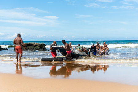 Salvador, Bahia, Brazil - May 23, 2021: Fishermen removing their canoe from the sea to place in the Boca do Rio fishermen colony.のeditorial素材