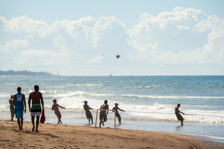 Salvador, Bahia, Brazil - May 23, 2021: Fishermen pulling the fishing net from the sea with fish inside. Boca do Rio beach in Salvador.のeditorial素材