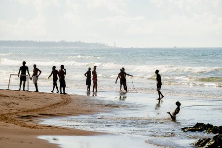 Salvador, Bahia, Brazil - May 23, 2021: Fishermen pulling the fishing net from the sea with fish inside. Boca do Rio beach in Salvador.のeditorial素材