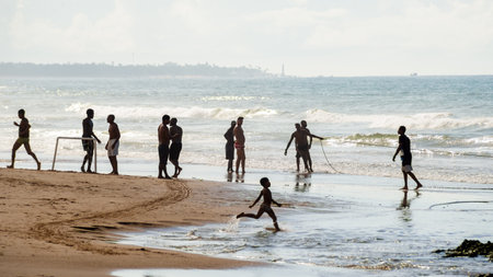 Salvador, Bahia, Brazil - May 23, 2021: Fishermen pulling the fishing net from the sea with fish inside. Boca do Rio beach in Salvador.のeditorial素材