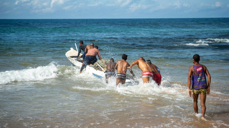 Salvador, Bahia, Brazil - May 23, 2021: Fishermen pulling their fishing canoe into the sea.のeditorial素材