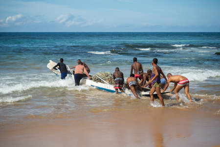 Salvador, Bahia, Brazil - May 23, 2021: Fishermen pulling their fishing canoe into the sea.のeditorial素材