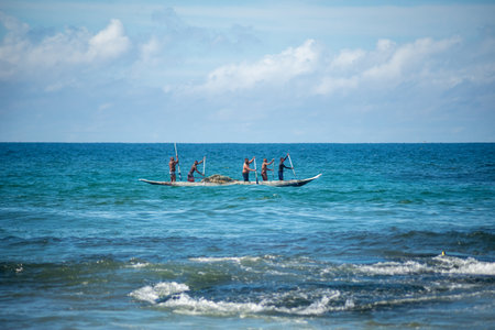 Salvador, Bahia, Brazil - May 23, 2021: Fishermen with oars in the con as entering the sea from Boca do Rio beach.のeditorial素材