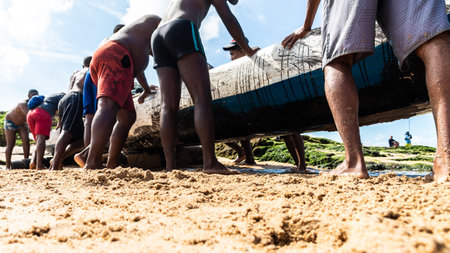 Salvador, Bahia, Brazil - May 23, 2021: Fishermen removing their canoe from the sea to place in the Boca do Rio fishermen colony.のeditorial素材