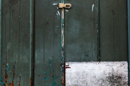 Antique iron padlock closing a wooden door or window in color. Pelourinho, Salvador, Bahia, Brazil.の写真素材
