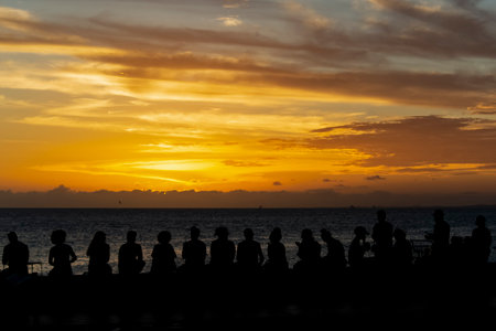 Silhouette of a person at the yellow sunset. Beach of Rio Vermelho, Salvador, Bahia, Brazil.の写真素材