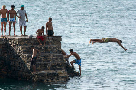 Salvador, Bahia, Brazil - January 08, 2019: Young people jumping into the sea from the Fort of Santa Maria pier in Porto da Barra.のeditorial素材