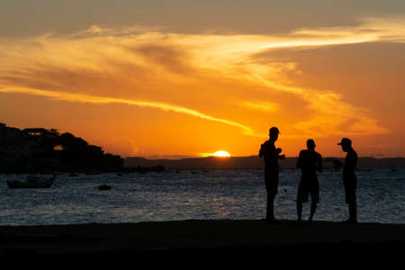 Salvador, Bahia, Brazil - March 09 2019: Silhouette of young people jumping from the Crush bridge at the yellow sunset on Ribeira beach in Salvador (BA).のeditorial素材