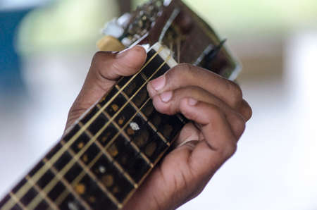 Left hand on the fretboard putting the chord to play. PituaÃ§u Park, Salvadol, Bahia, Brazil.の写真素材