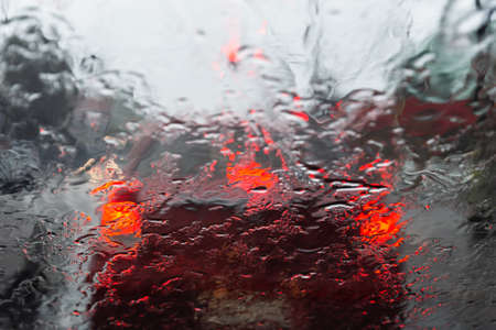 Salvador, Bahia, Brazil - June 13, 2021: Blurred colored lights through the car window with raindrops.の写真素材