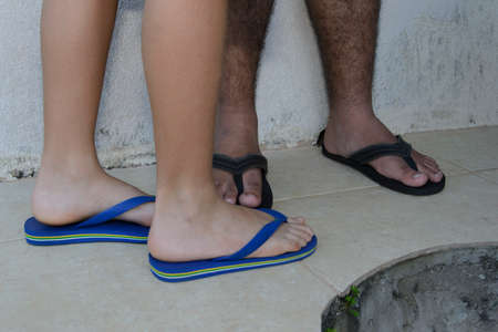 Legs and feet of young people wearing open sandals. Together talking in one place.の写真素材